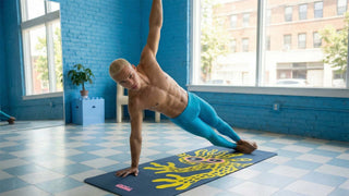 Yoga mat with a yellow creature Man performing a yoga pose in a room with blue walls and large windows.